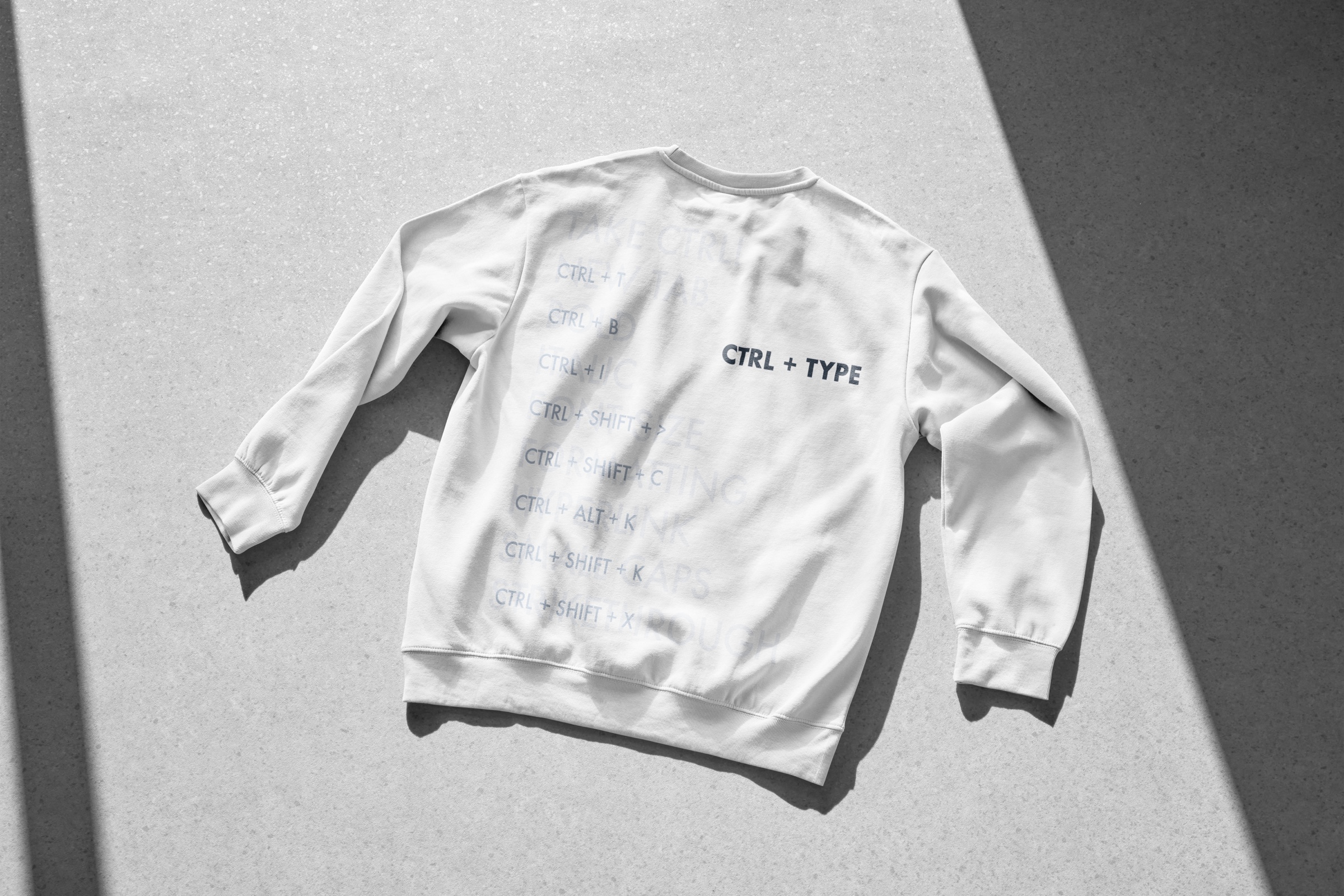 White sweatshirt printed with the CTRL + TYPE command-pattern identity.